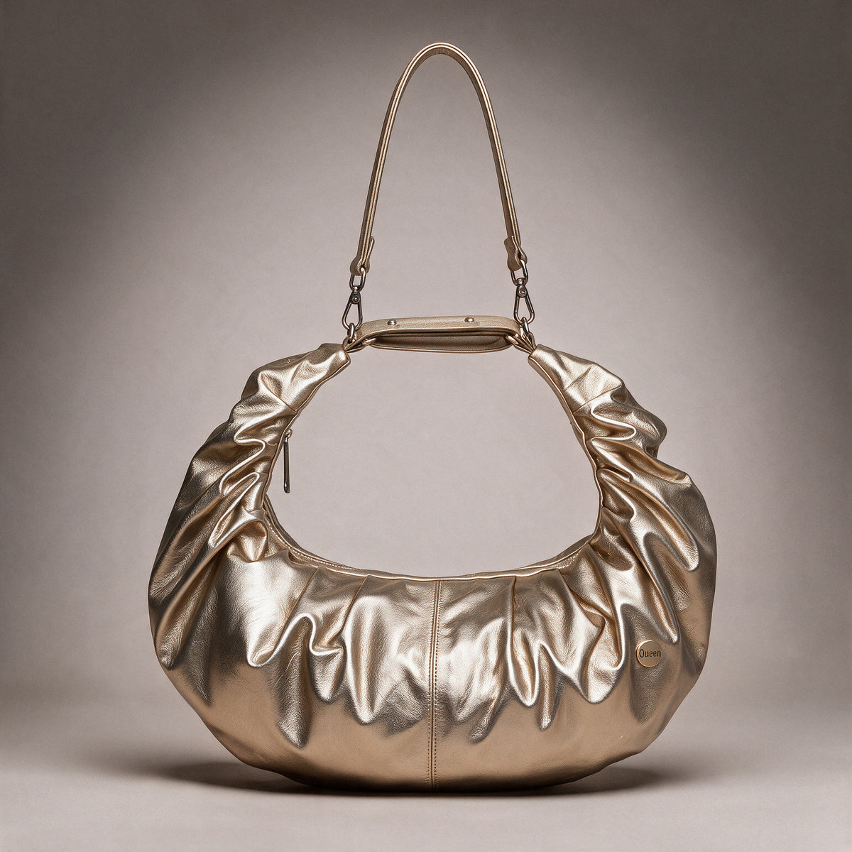 Bolso Renata Oro en cuero metálico dorado visto de frente sobre fondo greige de estudio