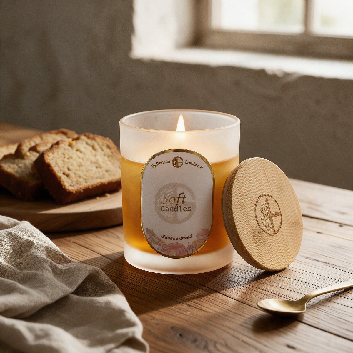 Vela Pan de Banano 8 Oz encendida sobre una mesa de comedor de roble junto a pan recién rebanado